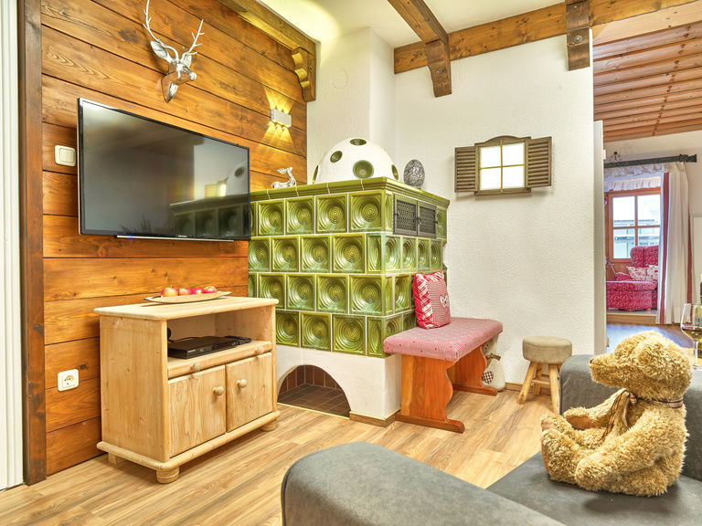 Wohnzimmer der Ferienwohnung Arbersee mit Kachelofen in Bodenmais